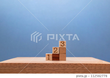 深い青色の背景上に並ぶ数字入りの3段のステップの正面 深い青色の背景上に並ぶ数字入りの3段のステップの正面 112582778