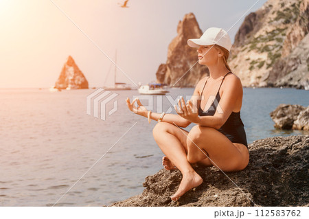 Woman sea yoga. Happy women meditating in yoga pose on the beach, ocean and rock mountains. Motivation and inspirational fit and exercising. Healthy lifestyle outdoors in nature, fitness concept. Woman sea yoga. Happy women meditating in yoga pose on the beach, ocean and rock mountains. Motivation and inspirational fit and exercising. Healthy lifestyle outdoors in nature, fitness concept. 112583762