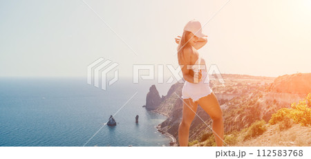 Woman summer travel sea. Happy tourist enjoy taking picture outdoors for memories. Woman traveler posing over sea bay surrounded by volcanic mountains, sharing travel adventure journey Woman summer travel sea. Happy tourist enjoy taking picture outdoors for memories. Woman traveler posing over sea bay surrounded by volcanic mountains, sharing travel adventure journey 112583768