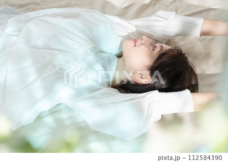 日差しを浴びて昼寝する女性 日差しを浴びて昼寝する女性 112584390
