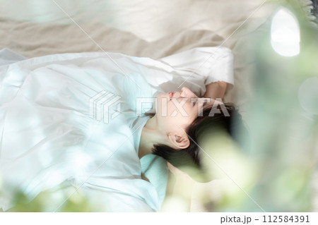 日差しを浴びて昼寝する女性 112584391