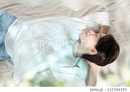 日差しを浴びて昼寝する女性 112584393