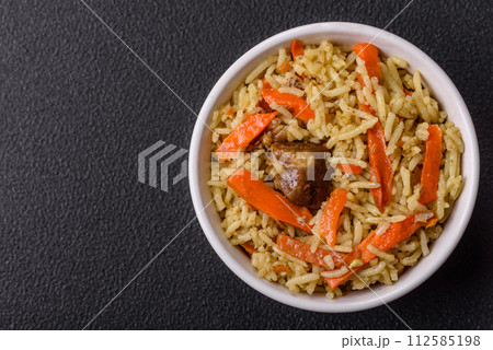 Delicious pilaf with vegetables, salt, spices and herbs in a ceramic plate Delicious pilaf with vegetables, salt, spices and herbs in a ceramic plate 112585198