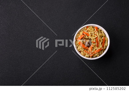 Delicious pilaf with vegetables, salt, spices and herbs in a ceramic plate 112585202