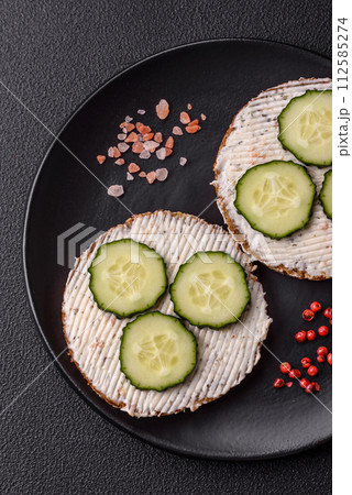 Delicious vegetarian sandwich with grilled toast, cream cheese, cucumbers and seeds 112585274