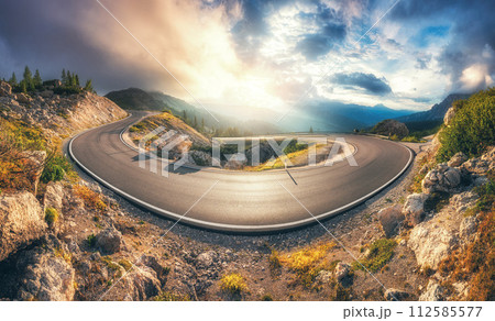 Mountain road at colorful sunset in summer. Curved roadway 112585577