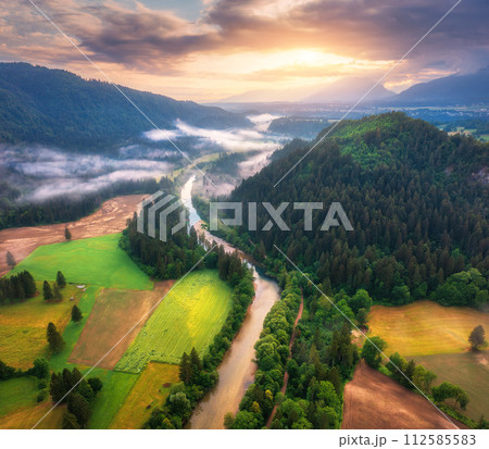 Aerial view of river in low clouds at sunrise in summer Aerial view of river in low clouds at sunrise in summer 112585583