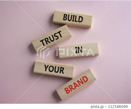 Build trust in your brand symbol. Wooden blocks with words Build trust in your brand. Beautiful pink background. Business and Build trust in your brand concept. Copy space. 112586099