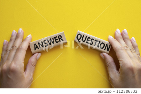 Answer or Question symbol. Concept word Answer or Question on wooden blocks. Businessman hand. Beautiful yellow background. Business and Answer or Question concept. Copy space Answer or Question symbol. Concept word Answer or Question on wooden blocks. Businessman hand. Beautiful yellow background. Business and Answer or Question concept. Copy space 112586532