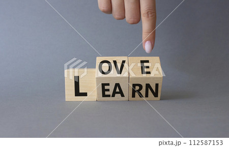 Love and Learn symbol. Businessman hand points at turned wooden cubes with words Learn and Love. Beautiful grey background. Lifestyle and Love and Learn concept. Copy space. Love and Learn symbol. Businessman hand points at turned wooden cubes with words Learn and Love. Beautiful grey background. Lifestyle and Love and Learn concept. Copy space. 112587153