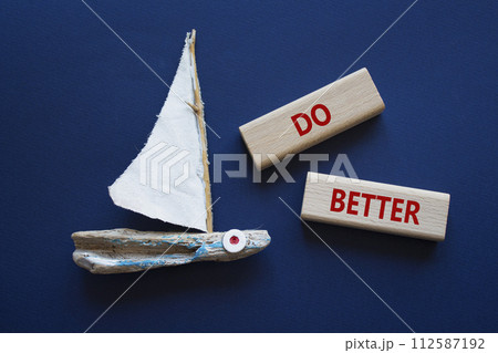 Do better symbol. Wooden blocks with words Do better. Beautiful deep blue background with boat. Business and Do better concept. Copy space. Do better symbol. Wooden blocks with words Do better. Beautiful deep blue background with boat. Business and Do better concept. Copy space. 112587192