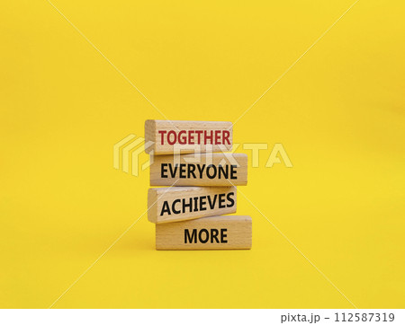 Together Everyone Achieves More symbol. Concept words Together Everyone Achieves More on wooden blocks. Beautiful yellow background. Business concept. Copy space. 112587319