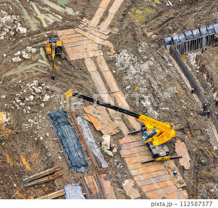 Excavator with hydraulic hammer or Backhoe and Heavy Industrial Crane, crane truck work at construction site. 112587377