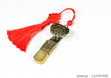 Traditional chinese brass amulet as presents. Chinese style amulet with red decorative good luck knots means good fortune, happiness and rich on white background. 112587405