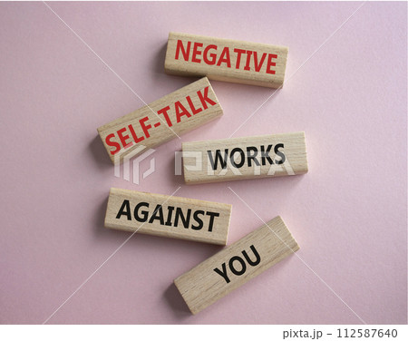 Negative self-talk works against you symbol. Concept words Negative self-talk works against you on wooden blocks. Beautiful pink background. Psychological concept. Copy space 112587640