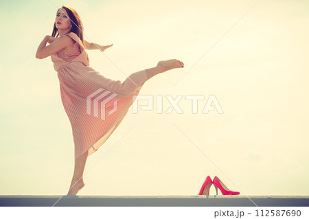Woman dancing wearing long light pink dress Woman dancing wearing long light pink dress 112587690
