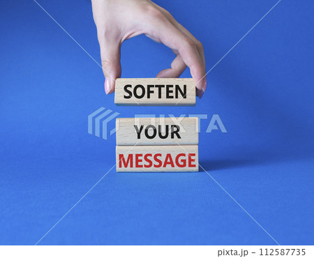 Soften your Message symbol. Concept words Soften your Message on wooden blocks. Beautiful blue background. Businessman hand. Business concept. Copy space. 112587735