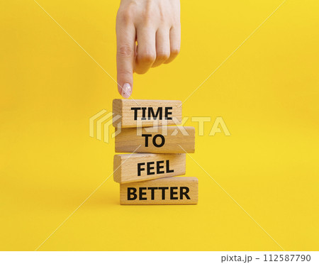 Time to feel better symbol. Wooden blocks with words Time to feel better. Businessman hand. Beautiful yellow background. Medicine and Time to feel better concept. Copy space. 112587790