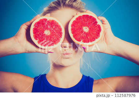 Woman holding grapefruit citrus fruit in hands 112587976