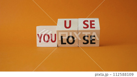 You use or lose symbol. Turned wooden cubes with words You lose or You use. Beautiful orange background. Business and You use or lose concept. Copy space You use or lose symbol. Turned wooden cubes with words You lose or You use. Beautiful orange background. Business and You use or lose concept. Copy space 112588109