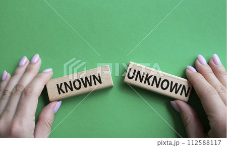 Known or Unknown symbol. Concept word Known or Unknown on wooden blocks. Businessman hand. Beautiful green background. Business and Known or Unknown concept. Copy space Known or Unknown symbol. Concept word Known or Unknown on wooden blocks. Businessman hand. Beautiful green background. Business and Known or Unknown concept. Copy space 112588117