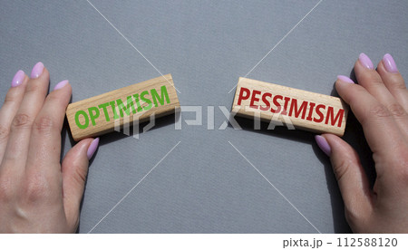 Optimism or Pessimism symbol. Concept word Optimism or Pessimism on wooden blocks. Businessman hand. Beautiful grey background. Business and Optimism or Pessimism concept. Copy space Optimism or Pessimism symbol. Concept word Optimism or Pessimism on wooden blocks. Businessman hand. Beautiful grey background. Business and Optimism or Pessimism concept. Copy space 112588120
