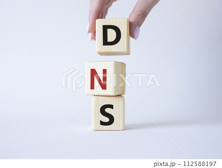 DNS -Domain Name Server - Consumer Price Index symbol. Concept word DNS on wooden cubes. Businessman hand. Beautiful white background. Business and DNS concept. Copy space. DNS -Domain Name Server - Consumer Price Index symbol. Concept word DNS on wooden cubes. Businessman hand. Beautiful white background. Business and DNS concept. Copy space. 112588197