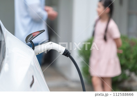 Focused electric vehicle recharging battery by home charging station. Synchronos 112588666