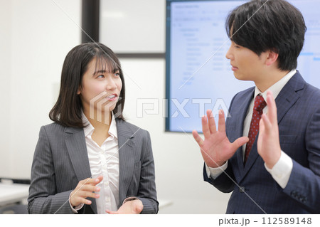 立って打ち合わせ_提案する女性に対し反対意見を持つ男性_3 立って打ち合わせ_提案する女性に対し反対意見を持つ男性_3 112589148