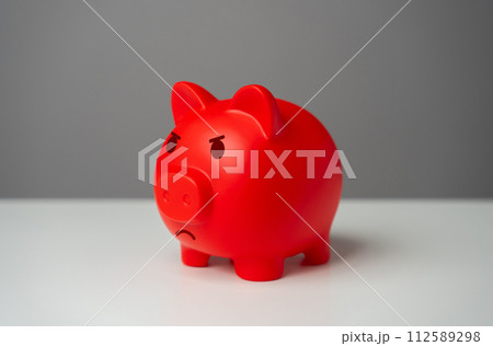 Angry red inflated piggy bank. Inflation is burning savings. Overheated financial market. Difficult economic conditions. Heavy burden on the budget, high expenses and the likelihood of bankruptcy. 112589298