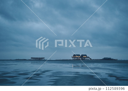 stilt house at sankt peter-ording germany on dark overcast day 112589396