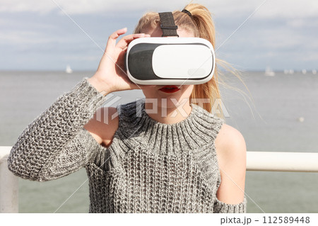 Woman wearing VR outside Woman wearing VR outside 112589448
