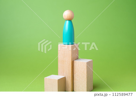 Man on a pedestal. Reach heights. Career success. Loneliness. Education and acquiring new skills. Reaching a high level of achievement, recognition Man on a pedestal. Reach heights. Career success. Loneliness. Education and acquiring new skills. Reaching a high level of achievement, recognition 112589477