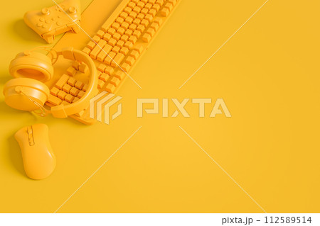 Modern home office setup featuring keyboard, gaming controllers and headphones 112589514