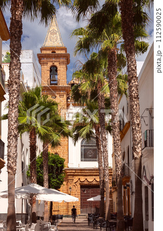 An old Catholic church against a backdrop of palm trees on a sunny day in Cadiz. An old Catholic church against a backdrop of palm trees on a sunny day in Cadiz. 112590025