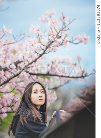 桜の下で手すりに手をかけている女子高生 桜の下で手すりに手をかけている女子高生 112591074