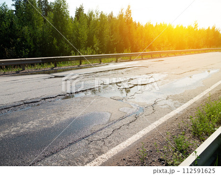 Potholes on bad asphalt road. Closeup 112591625