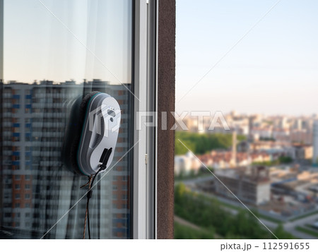 Vacuum cleaner washing windows. Home appliance and technology concept 112591655