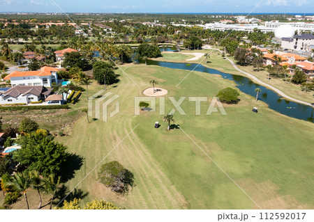 Golf club field with cart and playing golfers. Aerial view Golf club field with cart and playing golfers. Aerial view 112592017
