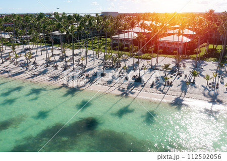 Sunset or sunrise on tropical beach with resorts, palm trees and caribbean sea. Dominican Republic. Aerial view Sunset or sunrise on tropical beach with resorts, palm trees and caribbean sea. Dominican Republic. Aerial view 112592056