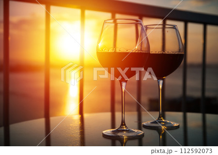 Two glasses with red wine in sunset 112592073