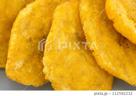 Fried platanos on plate. Sliced and cooked tostones 112592232