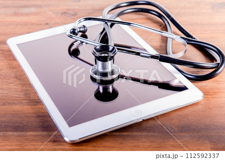 medical stethoscope and tablet on brown wooden background. Health care concept. phonendoscope. medical stethoscope and tablet on brown wooden background. Health care concept. phonendoscope. 112592337