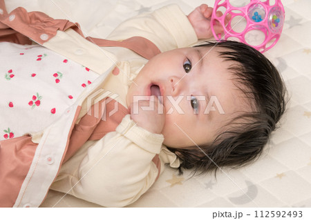 【指しゃぶりする赤ちゃんとおもちゃ】 112592493