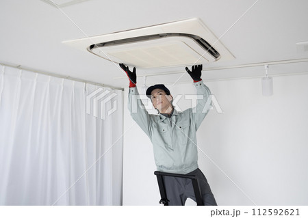 天上のエアコンの点検をする男性作業員 天上のエアコンの点検をする男性作業員 112592621