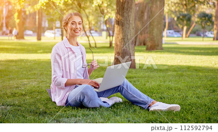 Businesswoman sitting grass summer park using Businesswoman sitting grass summer park using 112592794