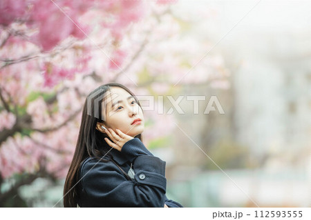 満開の桜の下で音楽を聴く女子高校生 112593555