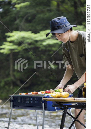 バーベキューイメージ　串焼きを焼く若い男性 112593785