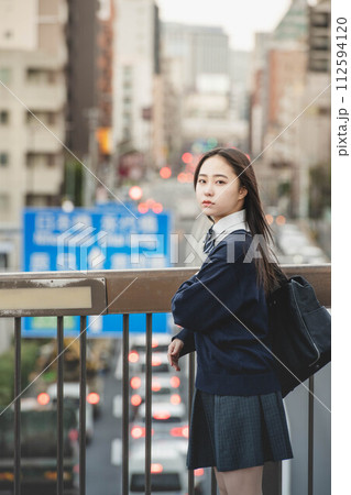 下校する女子高生と夕方の街並み 下校する女子高生と夕方の街並み 112594120