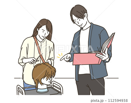 男性美容師にヘアマネキンを使いながらヘアカットの技術を教わる女性美容師 112594938